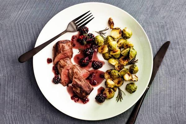 venison fillet in red wine sauce and blackberries with roasted sprouts