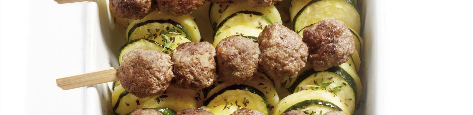 potato courgette dish with meat skewers