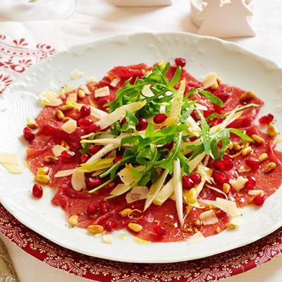 carpaccio with a salad of chicory, rocket and pomegranate seeds