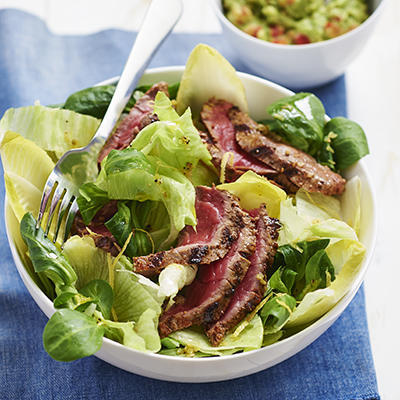 grilled steak with avocado sauce and salad